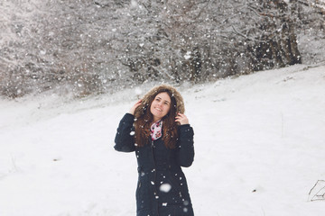 Winter portrait of a woman enjoying the snowfall