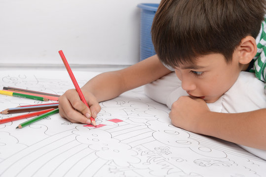 Little boy draw and painting pencil color on the paper home activities