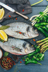 Dorado fish with lemon and spices on a wooden board