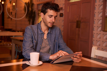 Concentrating young man sitting in restaurant