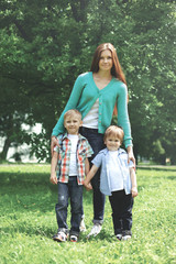 Happy family together! Mother and two children sons walking in the park on a summer day
