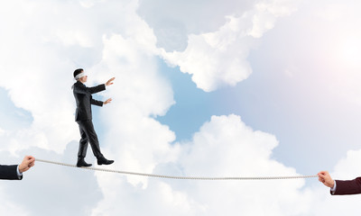 Obraz premium Business concept of risk support and assistance with man balancing on rope