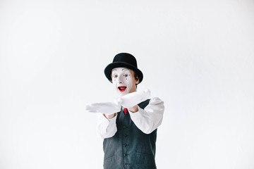 Smiling mime holds his palms like an airplane