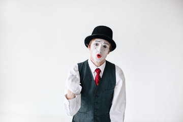 Mime tells something holding his fist up