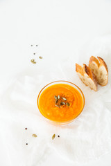 Two plates of pumpkin soup with seeds on a white background with space for your text.