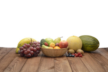 Bodegón de frutas variadas en un canasto sobre fondo de madera