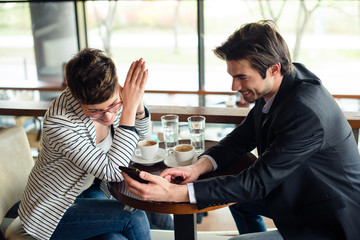 Man is showing woman phone