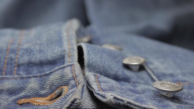 Extreme closeup rack focus shot of jeans button fly. Details in seams, buttons and textile pattern. Flat color profile.