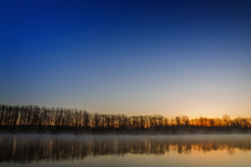 Morning dawn over the smooth surface of the spring river.