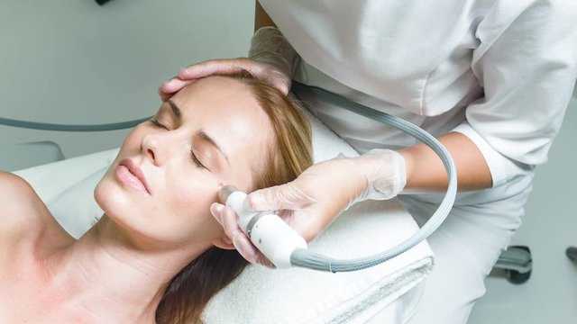 Calm lady having facial skin rejuvenation procedure