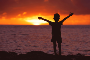 Fototapeta na wymiar Childhood concept with happy child at sunset beach
