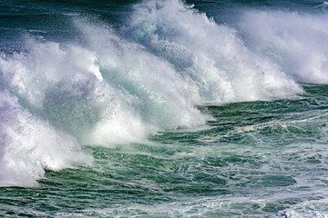 Wave crashing against rocks during storm