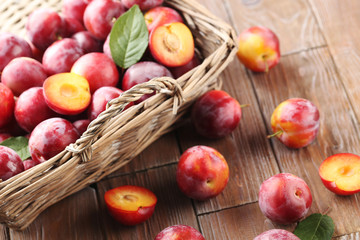 Fresh plums on a brown wooden table