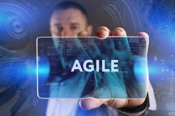 Business, Technology, Internet and network concept. Young businessman working on a virtual screen of the future and sees the inscription: Agile