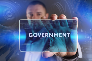 Fototapeta premium Business, Technology, Internet and network concept. Young businessman working on a virtual screen of the future and sees the inscription: Government
