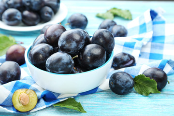 Tasty and ripe plums on blue wooden table