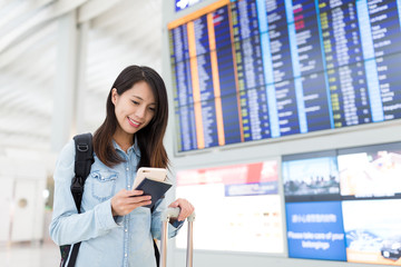 Young woman using cellphone in airport