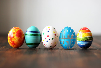 Easter colorful eggs on wooden background with egg shaped words Happy Easter.