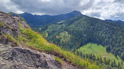 Fototapeta na wymiar Landscape with a pasture below and a mountain range under the clouds, a sunny summer day. View from Nosal Mountain, Tatry, Poland