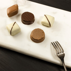 Various artisan chocolate bonbons with dessert fork