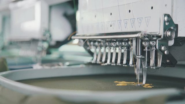 Embroidery needle, Needle with thread. Machine embroidery work.Machine embroidery is an embroidery process whereby a sewing machine or embroidery machine is used to create patterns on textiles.