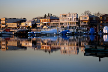 Reflection of coastline buildings in a calm bay