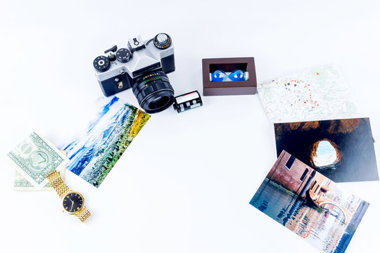 Top view of essentials for modern young person. Objects of traveller isolated on white background: map, camera, cash, film, watch, photos of Italy, Carpathians and the sea