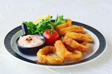 Calamary rings fried with spicy souce and rocca. Mediterranean lifestyle. Healthy food