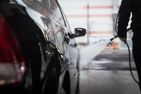 
Car wash services, a man washes the car with a kercher