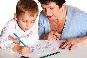 Grandmother with grandson learn and draw at table on a white background