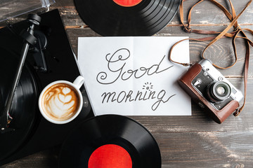 Photo of table with record-player, retro camera and records