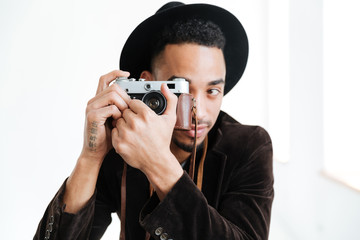 Fototapeta premium African man making photo on retro camera