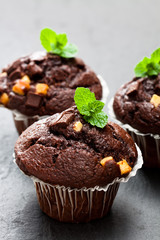 Triple  chocolate muffins on black stone background