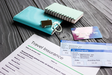 Travel preparation concept with insurance and cards on wooden table