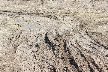 Dirty rutted road with pits and puddles in the spring.