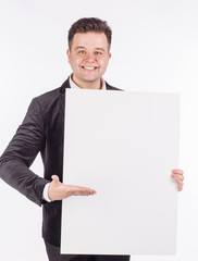 young man holding white blank panel with space for text on white background.