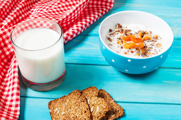 Homemade granola with milk for breakfast on blue wood background