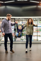 Vertical image of family walking and playing in supermarket