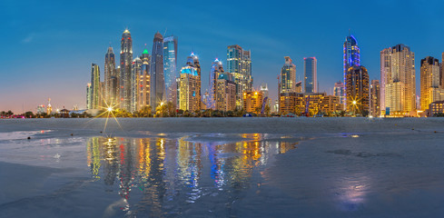 Naklejka premium Dubaj, Zjednoczone Emiraty Arabskie - 28 marca 2017: Wieczorna panorama Marina wieże od plaży.