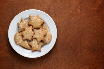 Homemade cookies with sesame in plate on wooden table