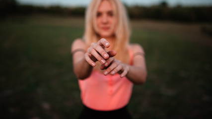 Pretty girl outdoor. Pulls his hands to the camera, selective focus