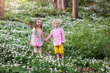Fototapeta premium Children in spring park with flowers