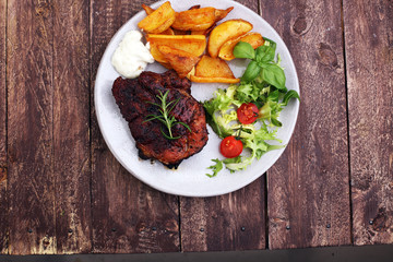 Grilled steaks, baked potatoes and salad