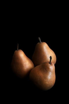 Brown pears on black background