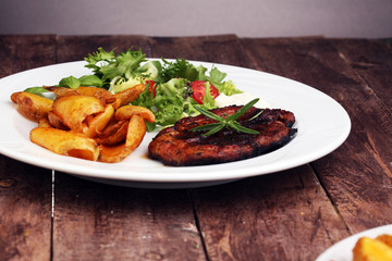 Grilled steaks, baked potatoes and salad