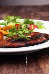 Grilled steaks, baked potatoes and salad