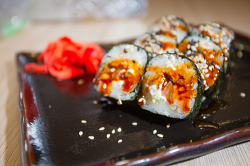 Japanese rolls with eel on black plate