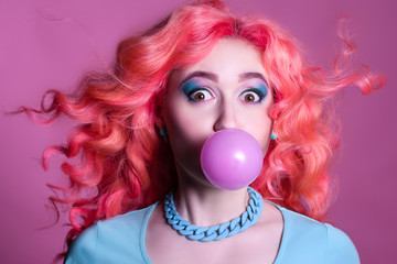 Girl with pink hair Chewing gum on a pink background and
