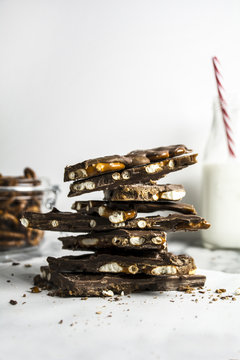 Stack of chocolate bark cookies with bottle of milk