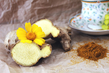 A cup of tea on a table with ginger and ground turmeric. Concept of health.